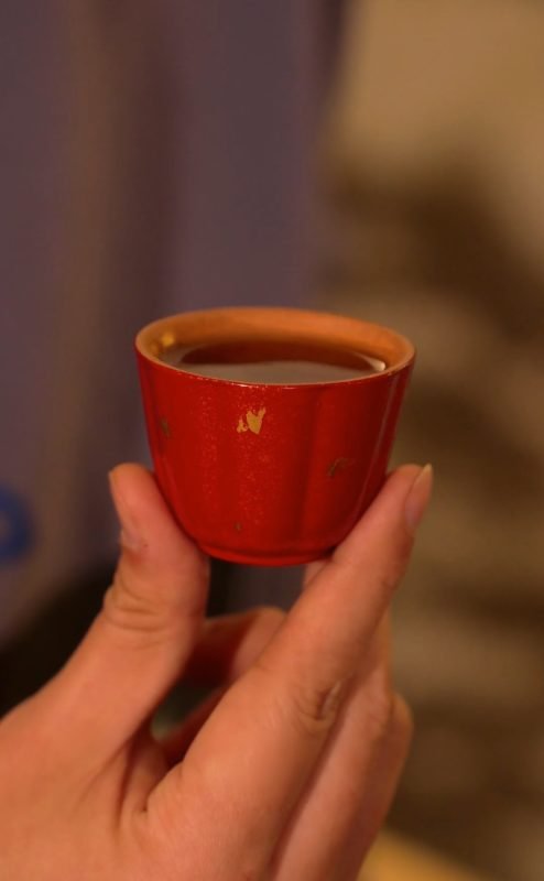 Hand holding a handmade tea bowl during a quiet tea ritual