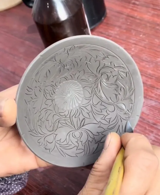 Artisan carefully finishing a handmade vessel as part of a traditional craftsmanship process