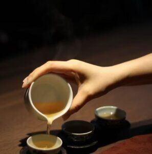 Warm tea being poured into a handmade ceramic tea cup