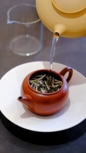 tea leaves unfolding in hot water during a traditional brewing process