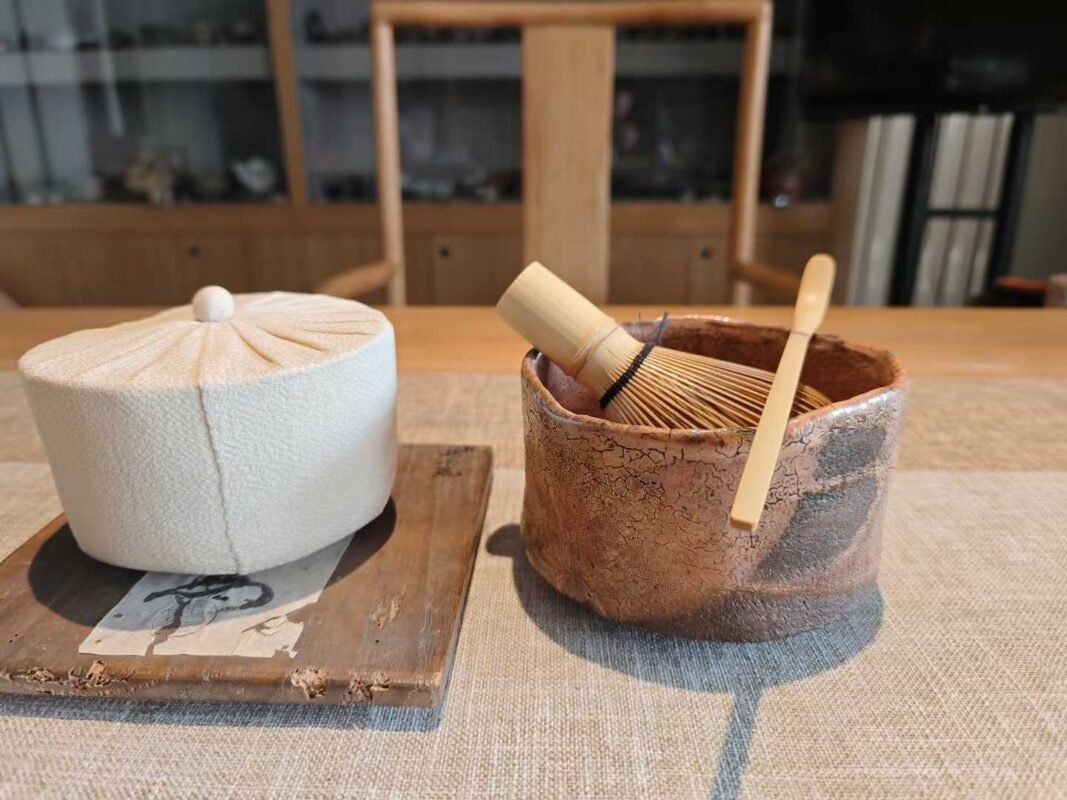 Aged tea ware arranged on wooden table with warm ambient light