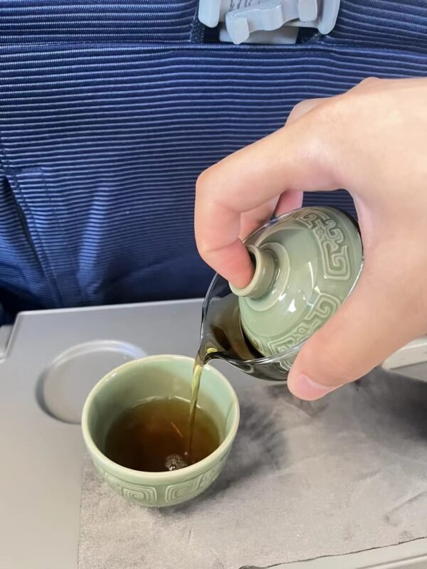 Handmade celadon tea cup beside a window with natural light