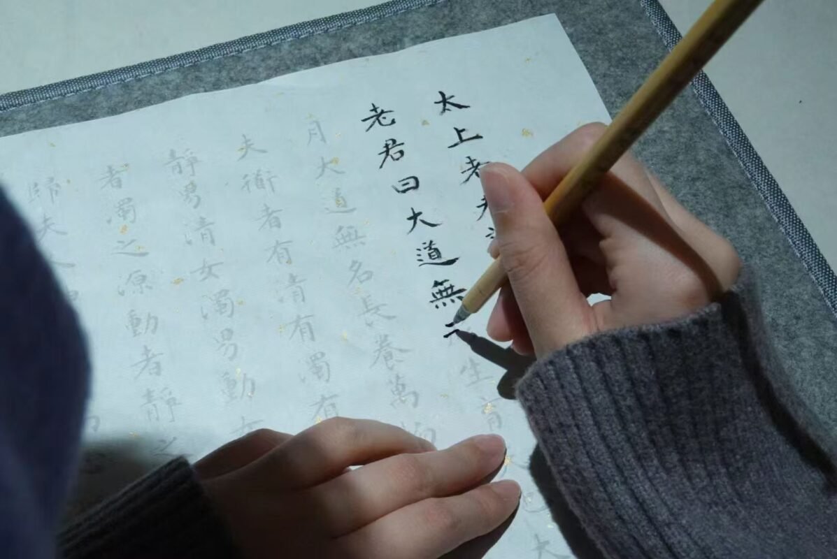 Close view of hand writing with brush in dim evening light