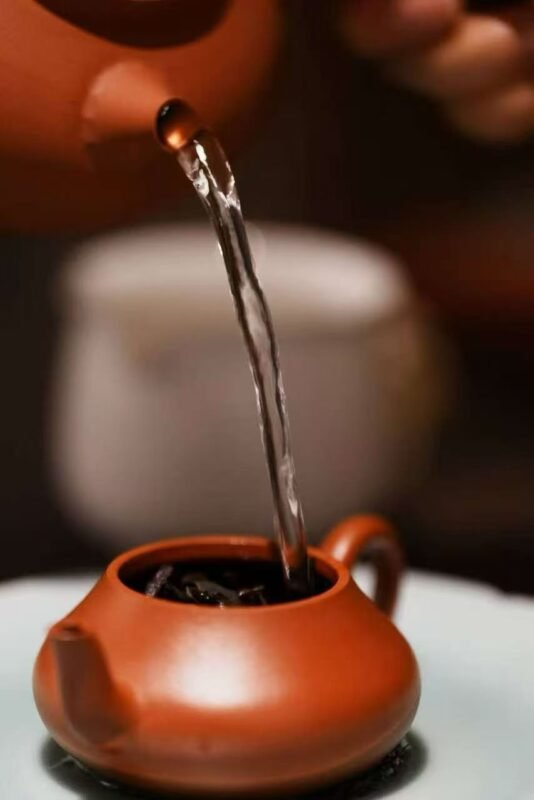 Slow tea pouring in a dim evening scholar setting