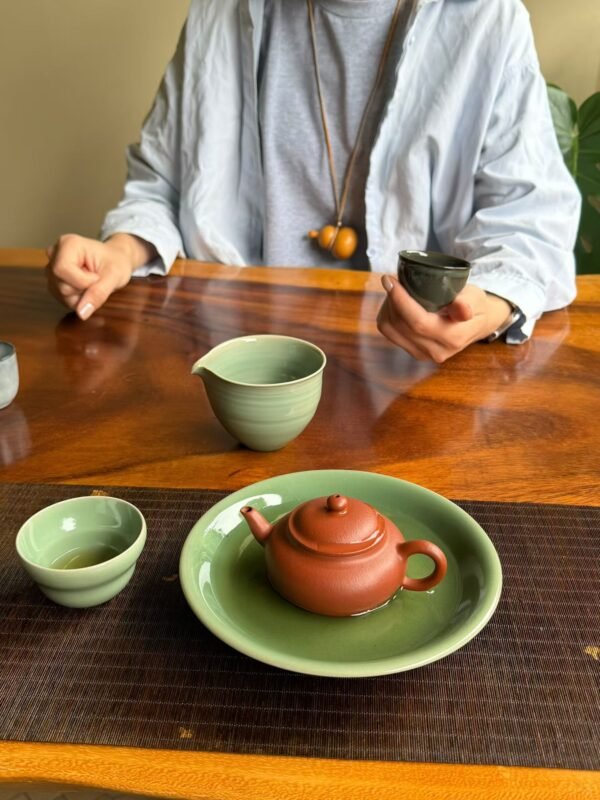 Handmade tea bowl resting comfortably in two hands during tea ritual