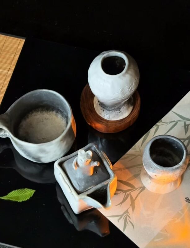 Several handmade clay tea bowls on wooden tea table with soft light