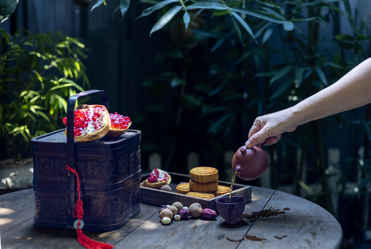 Hands holding a handmade ceramic tea cup during a quiet autumn evening